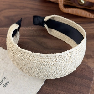 Macro detail of the beige woven headband texture with black non-slip lining on wooden tray