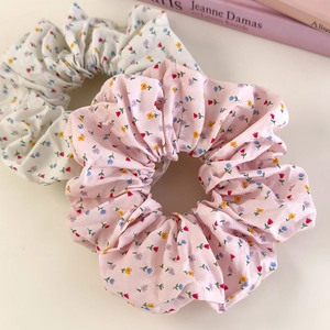 Set of two floral fabric scrunchies in pink and beige with delicate petal patterns