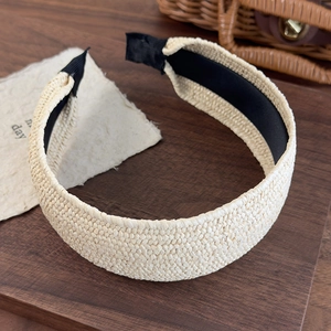 Detail of hand-woven cream straw headband with non-slip lining and fine braided texture
