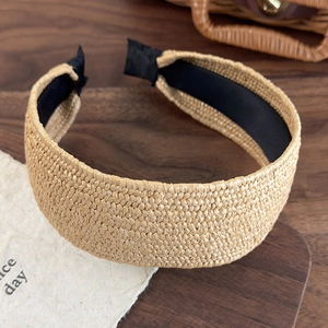 Detail of straw woven headband showing natural texture and black comfort lining