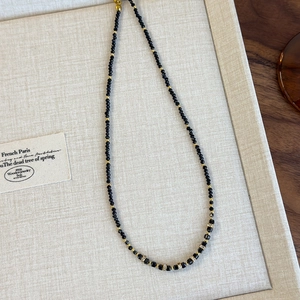 Dettaglio della collana di perline nere con accenti quadrati e zirconi scintillanti