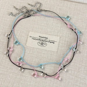 Detailed view of colorful cord necklaces with transparent water drop crystal pendants
