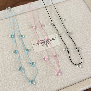 Detailed shot of three colorful cord necklaces with transparent resin teardrop beads