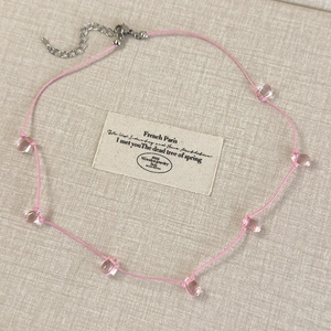 Detail of pink cord necklace with clear water drop beads and metal lobster clasp