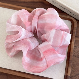 Détail du chouchou géant en mousseline tie-dye rose marbré avec texture plissée douce