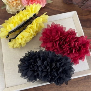 Vue détaillée de pinces à cheveux fleur en mousseline en jaune, bordeaux et noir
