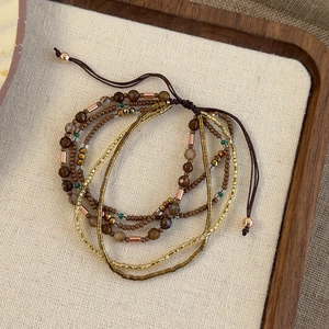 Close-up of bohemian layered beaded bracelet with brown agate and adjustable cord