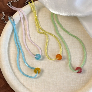 Detailed close-up of colorful acrylic beaded necklaces in blue, pink, yellow, and green