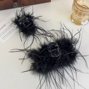Ensemble de deux pinces à cheveux en plumes noires montrant une texture douce et élégante