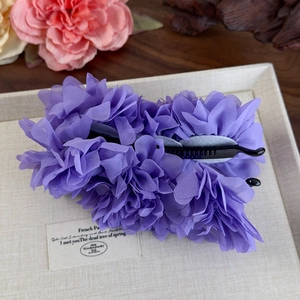 Détail de la pince banane fleurie en mousseline violette pour coiffure élégante