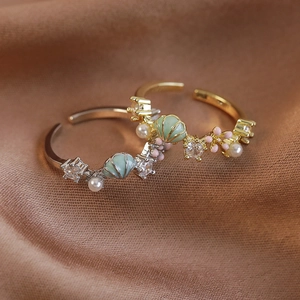Elegante goldene und silberne Ringe mit Minz-Emaille-Muscheln, Perlen und Zirkon