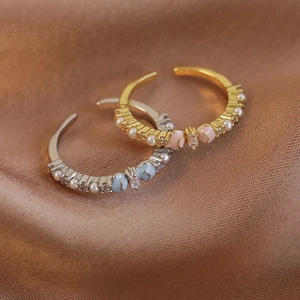 Bow open ring set with zircon pearls and enamel detail on silk fabric background