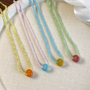 Detail view of colorful acrylic crystal beaded necklaces in yellow, pink, blue, and green