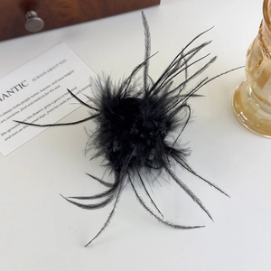 Détail d'une élégante pince à cheveux en plumes noires avec texture pelucheuse sur bois