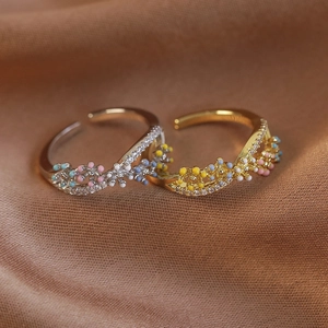 Close-up of interlocking floral rings with colorful enamel dots and micro-pave zircons
