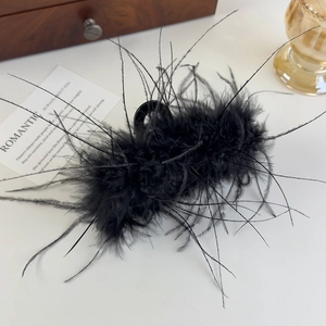 Détail d'une élégante pince à cheveux en plumes noires sur fond blanc décoratif