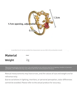 Detail of adjustable copper ring with white enamel flowers and red heart gemstone