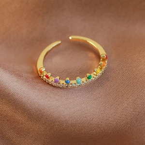 Vue macro d'une bague ouverte en or 18 carats avec émail arc-en-ciel et pavé de cristaux