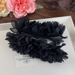 Détail de la barrette banane fleur en mousseline noire multicouche avec dents antidérapantes