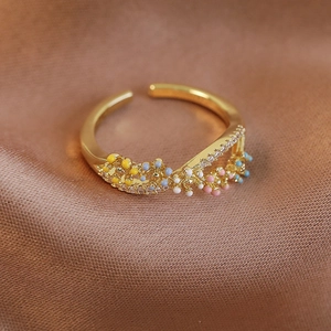 Detailed close-up of a gold-plated flower ring with colorful beads and zircon accents