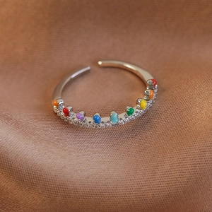 Détail de bague ouverte argentée avec points en émail coloré et pierres en zircone
