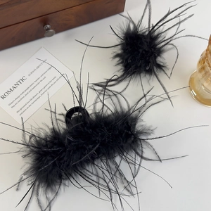 Kit élégant de pince à cheveux et chouchou en plumes noires sur fond en bois vintage