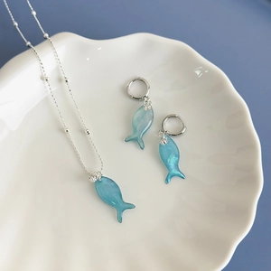 Blue tropical fish jewelry set with silver necklace and hoop earrings in shell tray