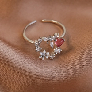 Detailed macro shot of an adjustable silver ring with a pink heart stone and white enamel flowers