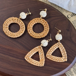 Handmade bohemian rattan earrings set with woven balls and gold metal details