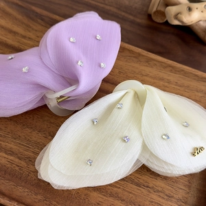 Vue détaillée des pinces à cheveux en tulle de style français avec strass et pendentif doré