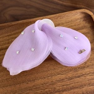 Détail de la pince à cheveux papillon en tulle violet avec strass et pendentif d'amour