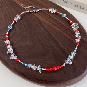 Detail of red and blue beads with irregular clear glass stones and silver metal tubes