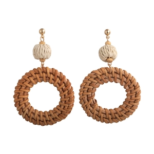 Detailed view of bohemian woven rattan hoop earrings with metal studs and wooden beads
