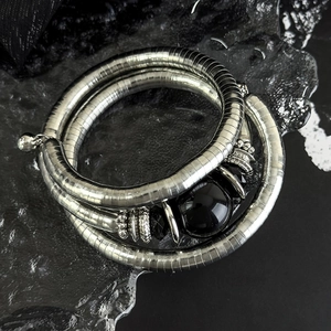 Macro view of multi-layer silver snake chain bracelet with polished black bead