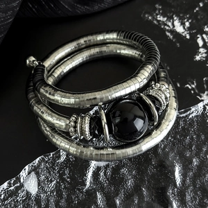 Detail of three-layer stretch bracelet with black stone and silver coiled metal texture