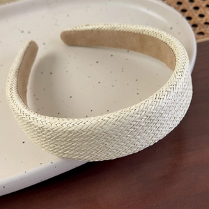 Close-up of beige straw woven wide headband with fine twill pattern on ceramic tray