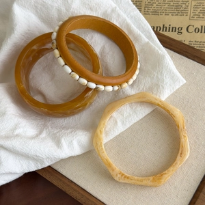 Nahaufnahme von Vintage-Armbändern aus Harz und Holz mit geometrischen Formen und Texturen