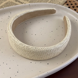 Detailed macro view of beige woven straw headband with soft non-slip inner lining texture