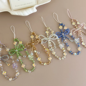 Detail of colorful crystal bead phone charms with bow accents and floral pendant