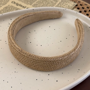 Detailed macro view of woven straw texture and soft velvet lining on a retro headband