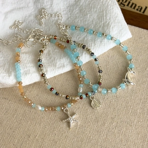 Blue ocean-themed beaded bracelets set with starfish, seashell, and dolphin charms