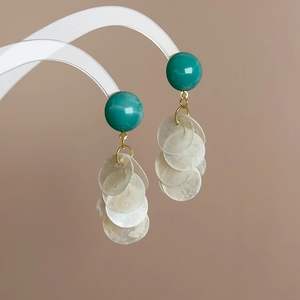 Détail des boucles d'oreilles coquillages vert avocat avec perles effet marbre