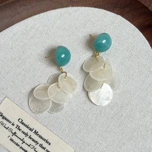 Détail des boucles d'oreilles en résine vert avocat avec pétales de coquillages nacrés