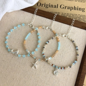 Blue beach beaded bracelet set featuring dolphin starfish and conch charms for summer