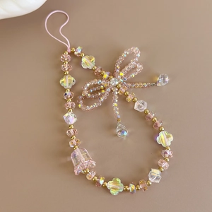 Close-up of pink beaded phone charm with crystal droplets and handcrafted ribbon bow