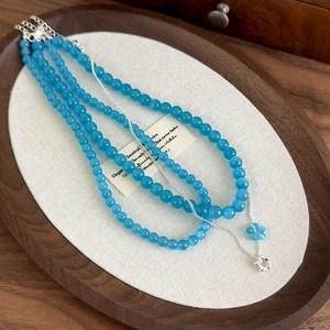 Three-piece layered necklace set with blue cat-eye stones and delicate floral pendant