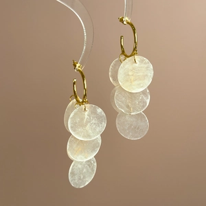 Detail of gold hoop drop earrings with layered shell-textured translucent discs