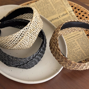French Bohemian straw woven wide headbands in beige, brown, and black displayed on a tray