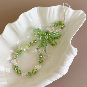 Detail of green crystal beaded phone strap with handmade bow and bellflower pendant