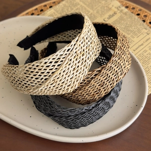 Detailed view of three-piece woven headband set in beige, brown and black colors